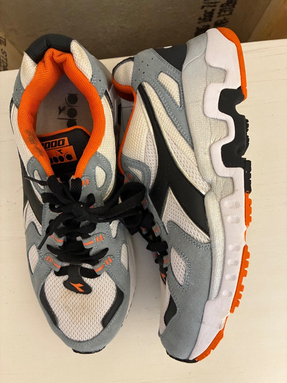 Diadora Mythos Suede sneakers feature a white, black, and orange colorway